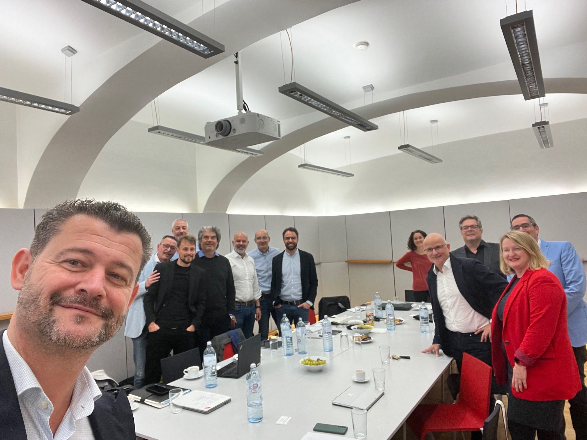 Fröhliches Selfie der Teilnehmer am Besprechungstisch